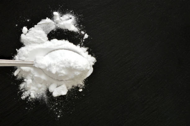 istock Baking soda on black background with copy space, flat lay 1472633371
