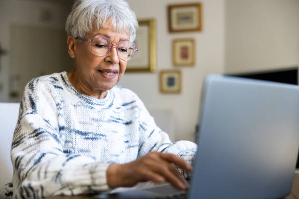 istock Senior woman using a laptop computer at home 1472634520