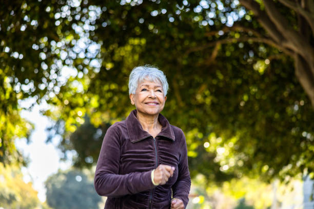 istock Senior woman running on a beautiful day outdoors under trees 1472634531