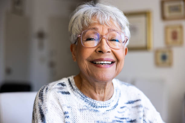 portret pięknej starszej rasy mieszanej w jej domu - portrait women human face glasses zdjęcia i obrazy z banku zdjęć