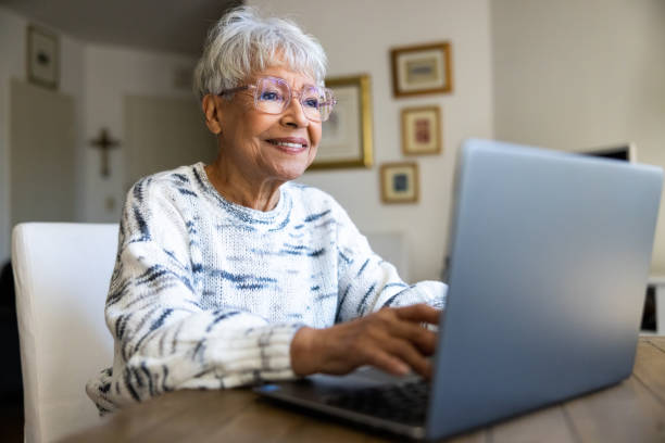 istock Senior woman using a laptop computer at home 1472635236