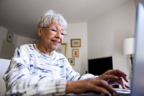 istock Senior woman using a laptop computer at home 1472635254