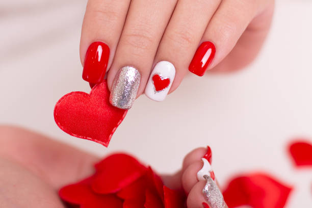 istock Female hands with red manicure nails, hearts design 1472641187