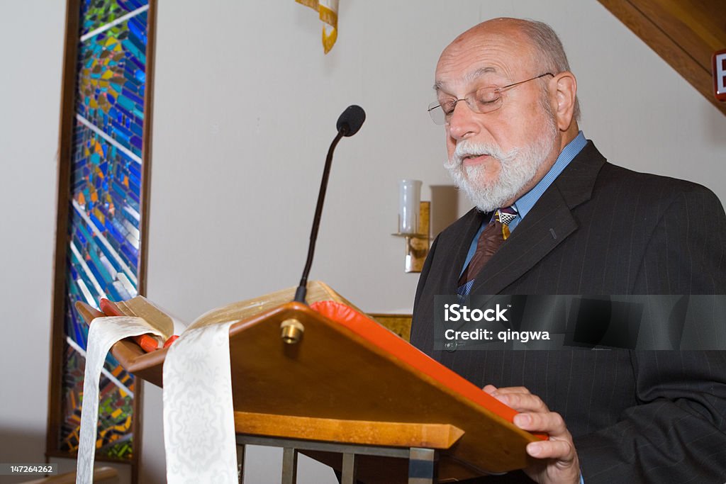 Senior hombre caucásico de lectura de la Biblia en podio en Church - Foto de stock de Atril - Objeto fabricado libre de derechos