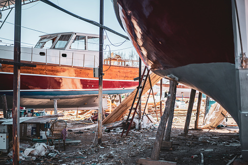 A small yacht stands on repairs supports in a dry dock