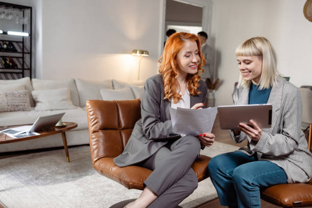 istock Two women are working together. They are sitting on chairs and using a digital tablet. 1472648782