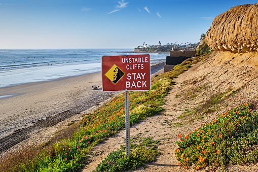Sign warns that the cliffs behind Pacific Beach, California are not stable