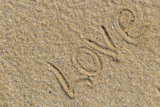 istock love message written in sand, background for design 1472650680