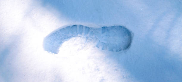 istock Human boots footprints in snow. Boot print on the snow. 1472652189