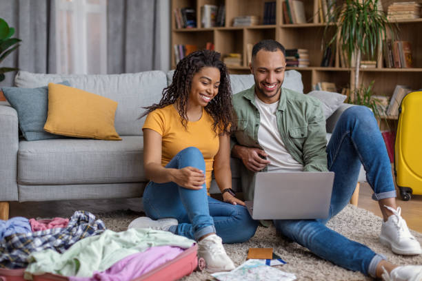 istock Excited black spouses using laptop while preparing for trip, choosing travel destination and booking tickets online 1472653386