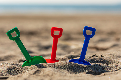 3 kids spades on a beach in Cornwall