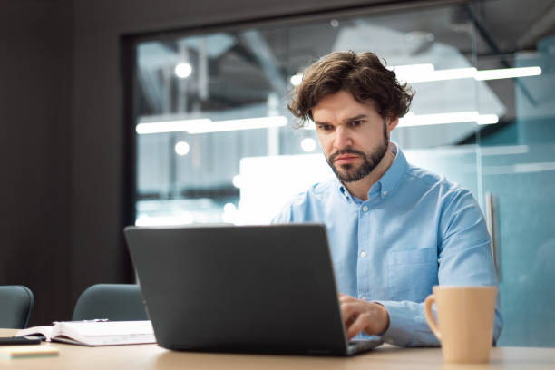istock Business man using laptop sitting at desk in office 1472661524