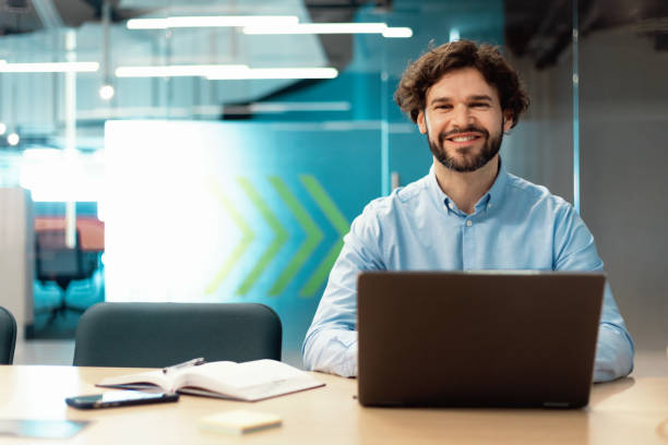 istock Portrait of smiling man using laptop and posing 1472661545
