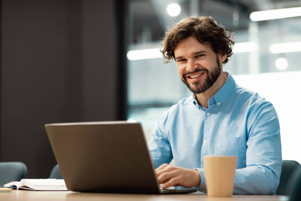 istock Portrait of smiling Arab man using laptop and posing 1472661547