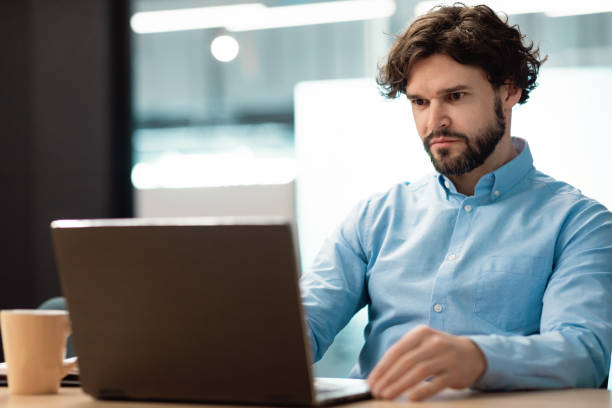 istock Business man using laptop sitting at desk in office 1472661549
