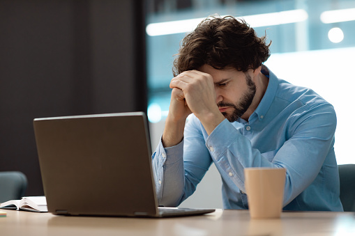 Error. Portrait of sad business man sitting at desk using pc with sad facial expression. Stressed guy suffering job problems, reading unexpected bad negative news, free copy space. Lack Of Inspiration