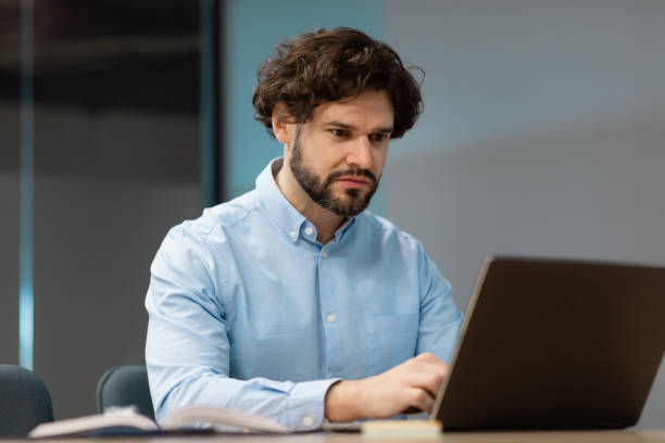 istock Business man using laptop sitting on chair in office 1472661557