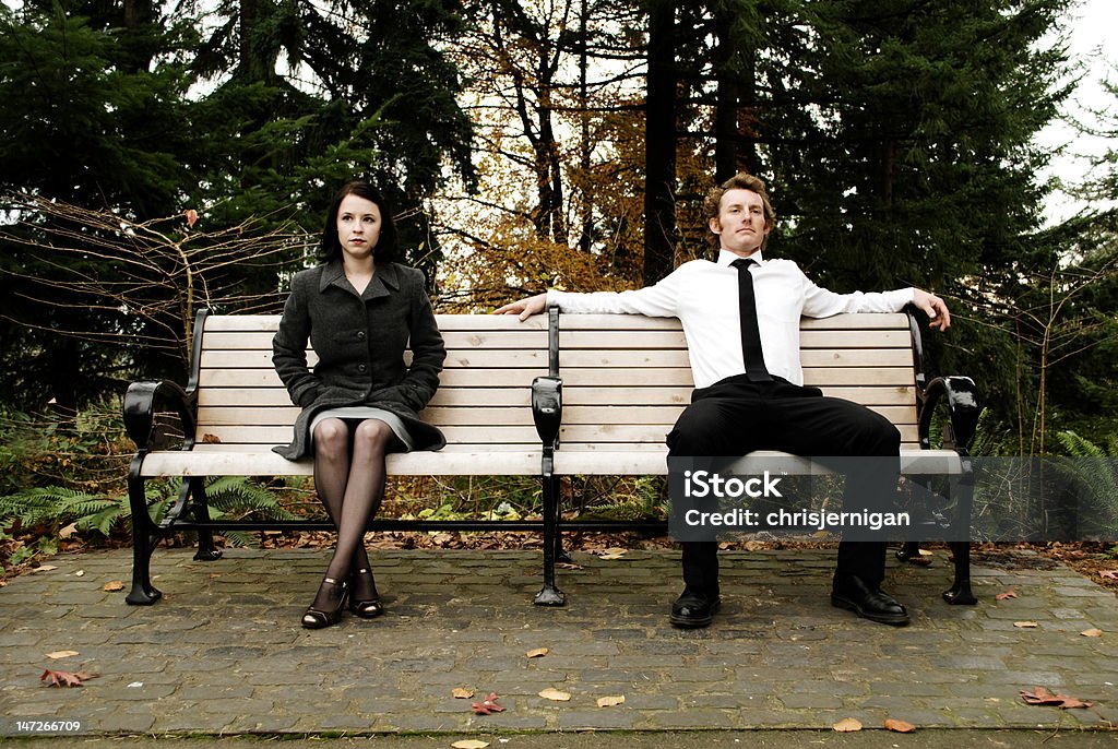 Ragazza e ragazzo seduto su parkbench - Foto stock royalty-free di Donne