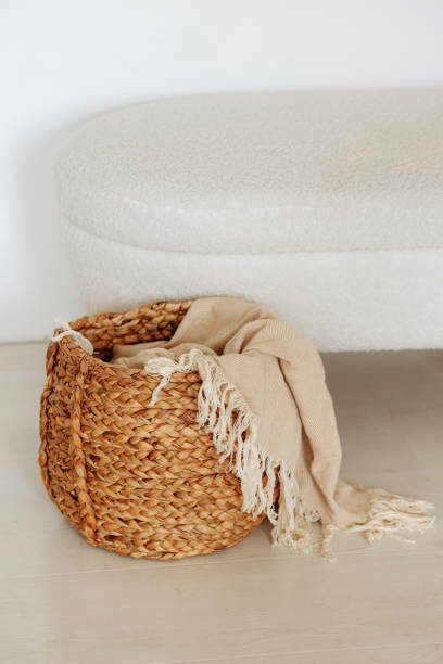istock Beautiful beige linen fabric rests inside a rustic woven basket. 1472667545