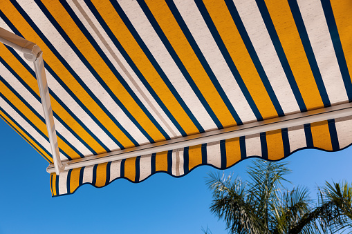 striped fabric awning against blue sky