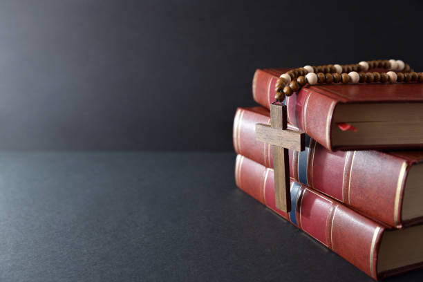 istock Religious books and cross isolated on black table and background 1472669582