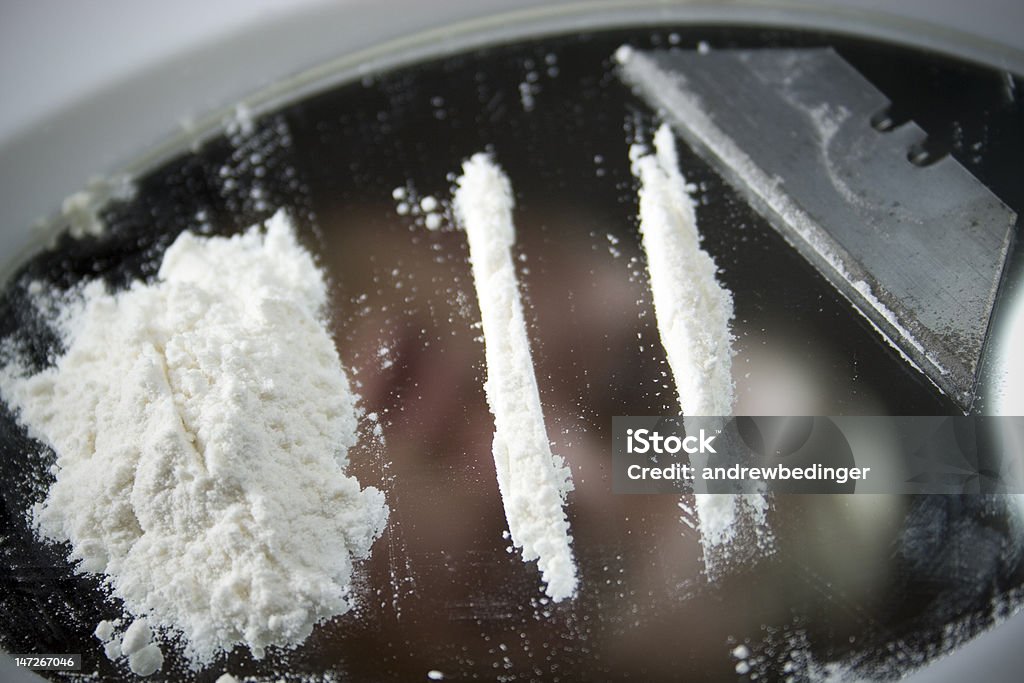 Coke addict Coke addict reflected in mirror looking at cocaine Addiction Stock Photo