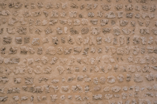 Traditional stone, coral and adobe wall in Sharjah emirate in the United Arab Emirates. Such hand plastered walls were made for centuries in the Arabian Gulf with materials from the desert and sea