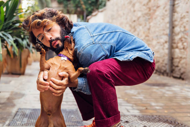 istock young man with beard kissing his little dog 1472672576