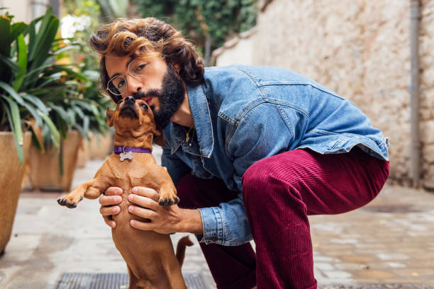 istock young man with beard kissing his little dog 1472672583