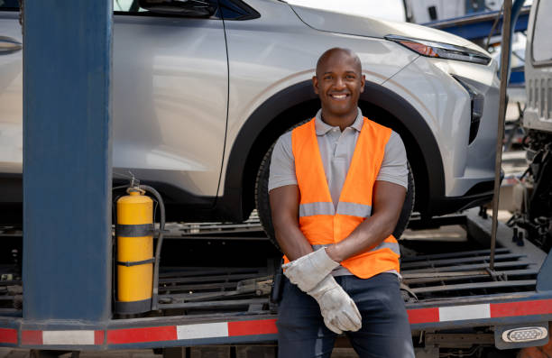 istock Man working at a distribution warehouse and loading vehicles on a car transporter 1472673458