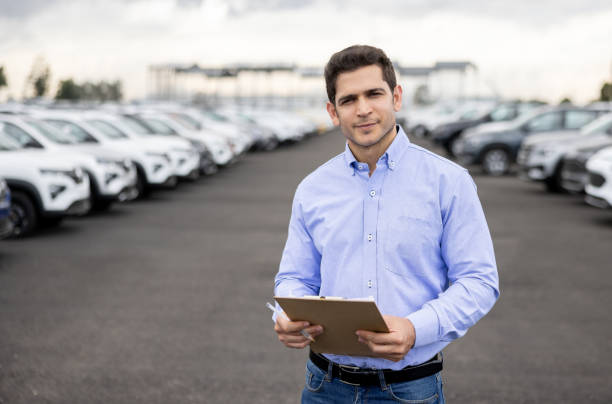 istock Salesman using a tablet at a car dealership 1472673505