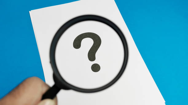 istock Question mark concept. White paper with question mark symbol and magnifying glass. 1472675607