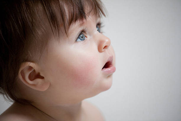 niña bebé mirando hacia arriba - piel enrojecida fotografías e imágenes de stock