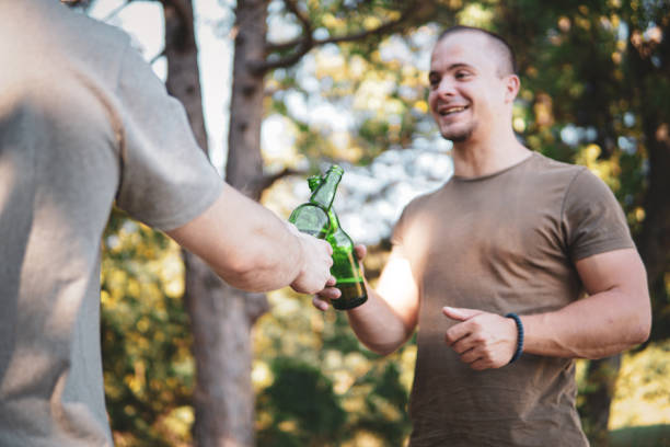 istock Two men clinking beer in nature, cheers, having a celebrating toast 1472682587
