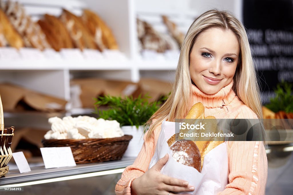 Young woman The young girl with bread in shop Adult Stock Photo