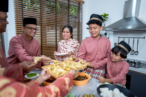 Family in traditional clothing having a dinner together