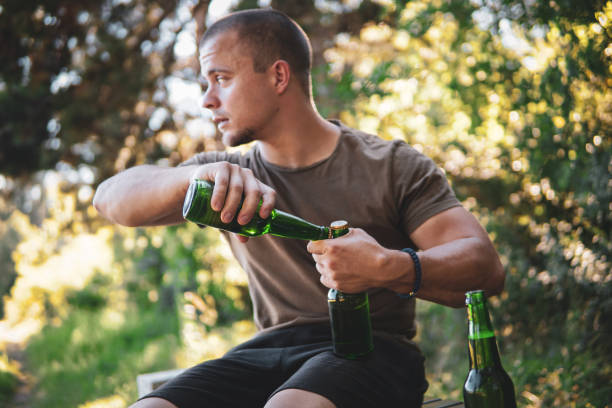 istock Man opening one beer bottle with another 1472695705