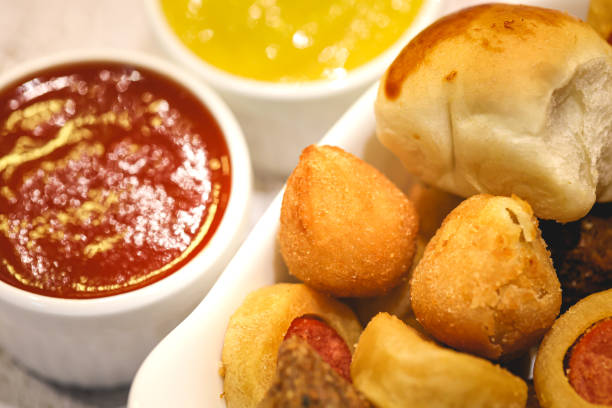 istock Assorted Brazilian snacks inside a baking dish and pots with ketchup and mustard in the background. Brazilian food, snack, appetizer, salty snack. 1472696748