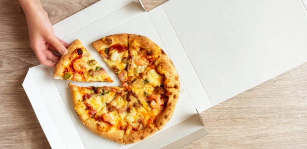 istock Pizza in a delivery cardboard box on the table 1472698816