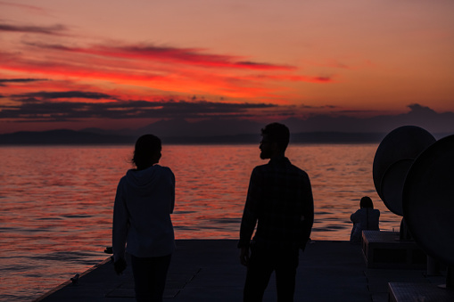 Seattle, USA - Oct 10th, 2022: A vivid sunset over pier 62 on Elliott bay as people enjoy the warm weather.