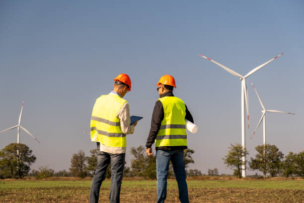 istock Engineers control work of modern wind farm in countryside 1472707528
