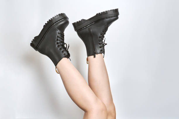 러그 밑창이 거꾸로 된 하이힐 플랫폼에 검은색 전투화를 신은 여자 다리, 흰색 배경 - at the bottom of boot sole of shoe shoe 뉴스 사진 이미지