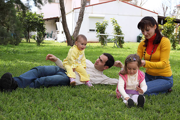 Family on a lawn in front of the house stock photo