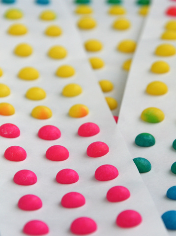 strips of paper with colorful candy dots background