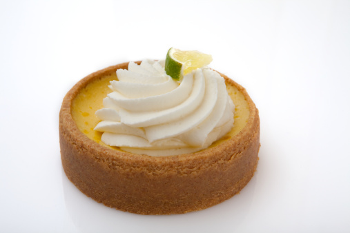 Lime tart with whipped cream on a white background