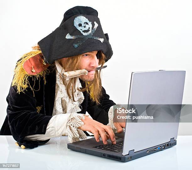 Man Dressed As Pirate With A Knife In His Mouth On A Laptop Stock Photo - Download Image Now