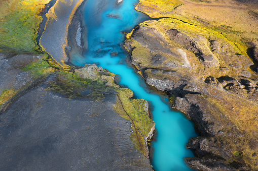 Aerial view on idyllic turquoise river in Iceland illuminated by the sunlight.