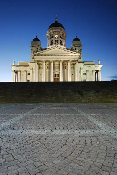 Helsinki cathedral at night with cobblestone pavement in foreground. No tourists visible. Gradation filter used to balance lights