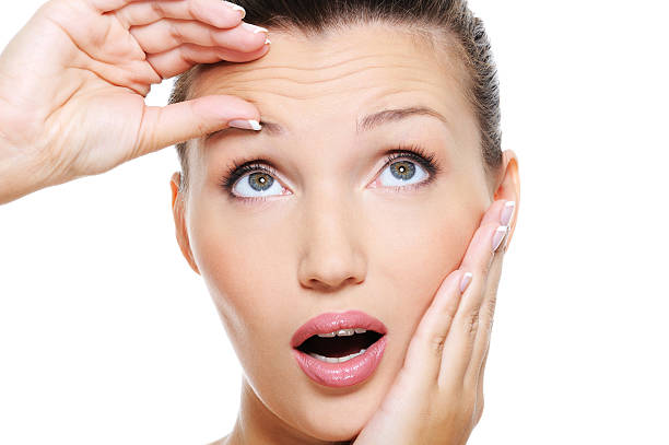 istock young pretty woman squeeze skin on forehead 147272160