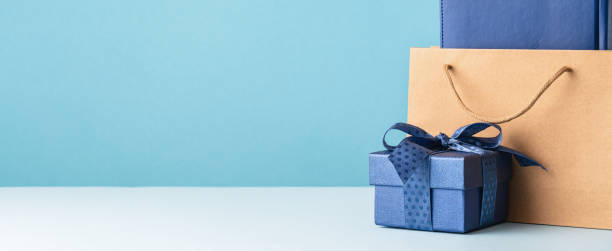 istock one gift box with a blue bow and paper bag on desk 1472722936